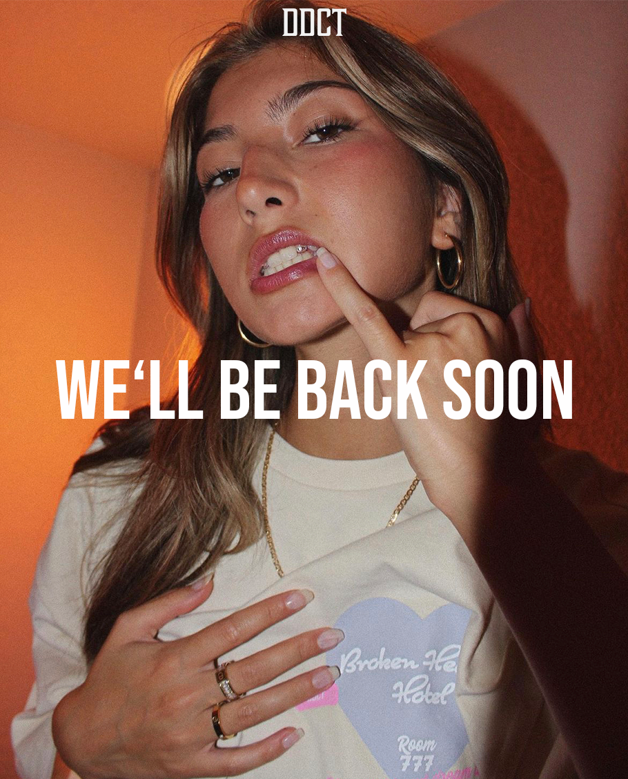 We'll be back soon" - Ein inspirierender Schriftzug auf einem ansprechenden Hintergrundbild. Eine hübsche Frau trägt das Broken Hearts Hotel Tee und versprüht Streetwear-Charme. Bald sind wir wieder für euch da!